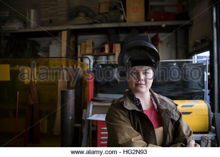 Portrait confident female welder wearing protective workwear in workshop