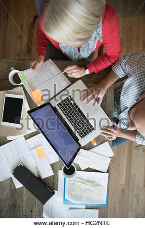 Overhead view senior couple with laptop paying bills online