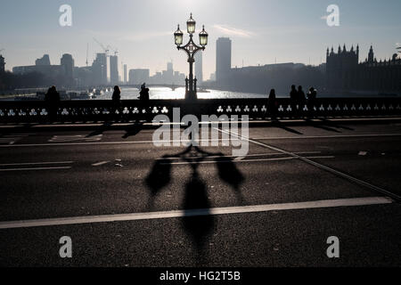 Westminster bridge shadows cast by Victorian ornate lampposts on misty early morning Stock Photo