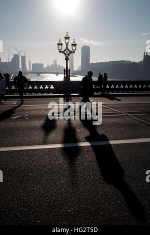 Westminster bridge shadows cast by Victorian ornate lampposts on misty early morning Stock Photo