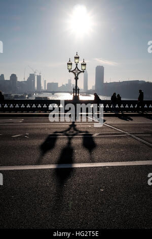 Westminster bridge shadows cast by Victorian ornate lampposts on misty early morning Stock Photo