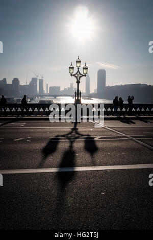 Westminster bridge shadows cast by Victorian ornate lampposts on misty early morning Stock Photo