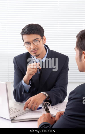 Young professional man listening patiently to another professional man at office Stock Photo