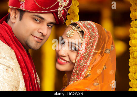 Handsome groom and beautiful bride looking at camera , young couple Stock Photo