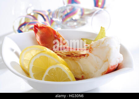 Half a boiled rock lobster garnished with lemon slices Stock Photo
