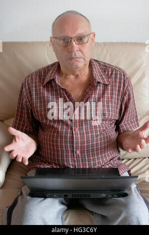 Senior Mature Man using a black Laptop Stock Photo