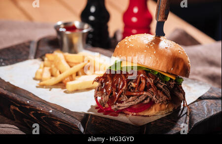 Close up of big burger being served with French fries Stock Photo
