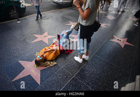 Young girl posing next to Johnny Depp´s star at Hollywood Walk of Fame, Los Angeles, California. Stock Photo