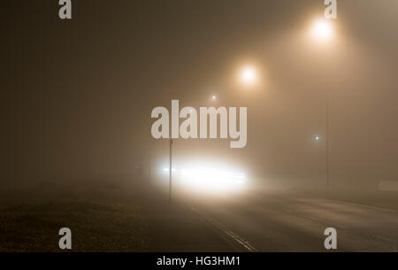 Main road at night in heavy fog, in the UK. Foggy weather. Mist at night. Fog at night. Dangerous conditions. Driving in fog. Stock Photo