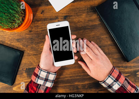 Casual female graphic designer using smart phone, top view of office desktop Stock Photo