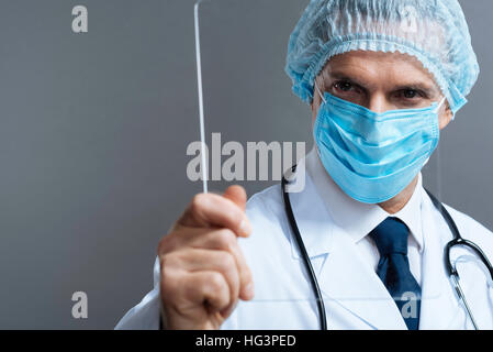 Attractive doctor in face mask holding a glass Stock Photo