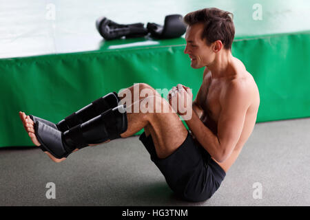 Young man shakes abdominal muscles Stock Photo