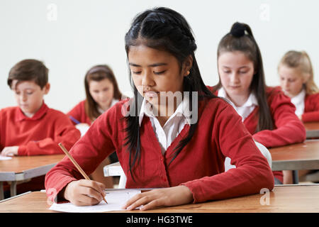 Female Pupil At Desk Taking School Exam Stock Photo