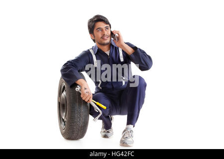 Car mechanic using cell phone Stock Photo