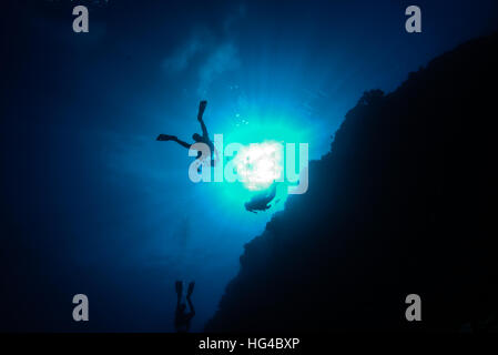 scuba divers swimming along coral reef wall.  at Yap island Micronesia. Stock Photo