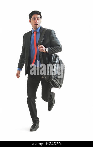 Young businessman holding briefcase and running Stock Photo