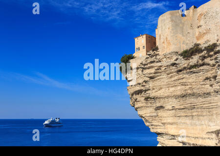 Old citadel atop cliffs with cruise ship anchored off shore, Bonifacio, Corsica, France, Mediterranean Stock Photo