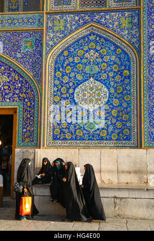 Girls gossiping after shopping in the Grand Bazaar, by entrance of Sheikh Lotfollah Mosque, Isfahan, Iran, Middle East Stock Photo