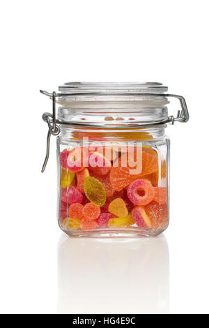 Candy jar on white background. Jar filled with brightly colored sweets (fruity jelly sweets). Stock Photo