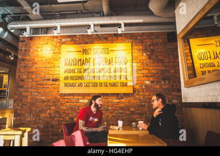 London, 2 friends men on the table drinking a coffee and talk inside the Pret a Manager coffee bar Stock Photo