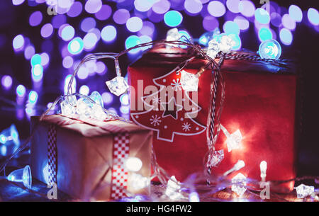 Christmas gift boxes with glowing garland and blue bokeh lights Stock Photo