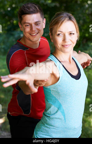 Mature Woman With Yoga Coach In Park Stock Photo