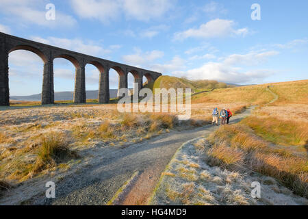 Walkers pass the Ribblehead viaduct on their way to Whernside, North Yorkshire National Park, England, UK Stock Photo