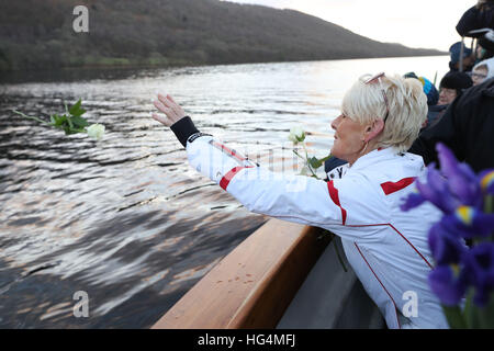 Gina Campbell, the daughter of world land and water speed record holder Donald Campbell, casts flowers on to the waters of Lake Coniston to mark the 50th anniversary of the fatal crash there of his jet-powered Bluebird boat. Stock Photo