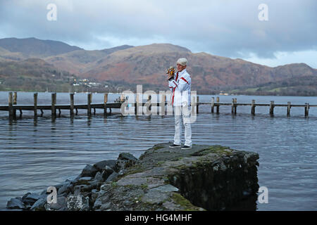 Gina Campbell, the daughter of world land and water speed record holder Donald Campbell, holds his mascot, a teddy bear named Mr Whoppit, as she marks the 50th anniversary of the fatal crash there of his jet-powered Bluebird boat at Lake Coniston. Stock Photo