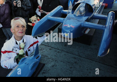 Gina Campbell, the daughter of world land and water speed record holder Donald Campbell, holds his mascot, a teddy bear named Mr Whoppit, as she visits a memorial at Lake Coniston to mark the 50th anniversary of the fatal crash there of his jet-powered Bluebird boat. Stock Photo