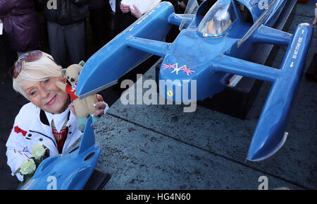 Gina Campbell, the daughter of world land and water speed record holder Donald Campbell, holds his mascot, a teddy bear named Mr Whoppit, as she visits a memorial at Lake Coniston to mark the 50th anniversary of the fatal crash there of his jet-powered Bluebird boat. Stock Photo