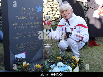 Gina Campbell, the daughter of world land and water speed record holder Donald Campbell, places his mascot, a teddy bear named Mr Whoppit, beside his grave at Lake Coniston as she marks the 50th anniversary of the fatal crash there of his jet-powered Bluebird boat. Stock Photo