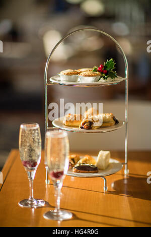 Champagne glasses with mince pies and holly at Christmas Stock Photo