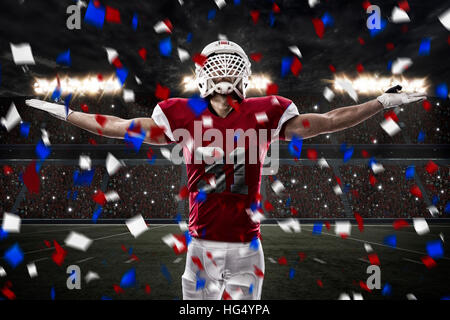 Football Player with a red uniform celebrating, on a stadium. Stock Photo