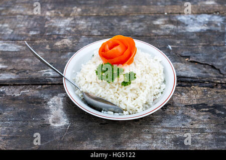 The plate with boiled rices on the old table Stock Photo