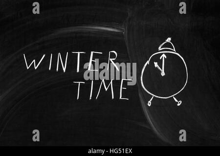 winter time handwritten on a chalkboard with chalk Stock Photo