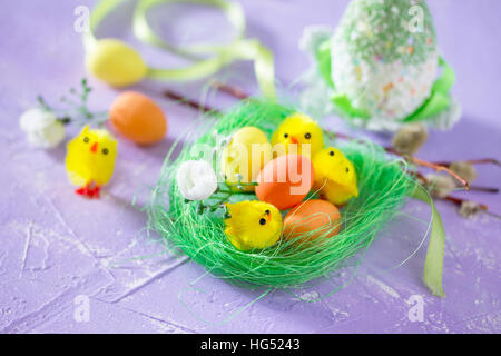 Colorful Easter frame -perepelinnye eggs in the nest and chicks, space for text. Stock Photo