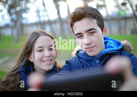 Teenagers taking a selfie in park Stock Photo