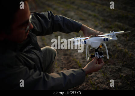 Young man flying Phantom Drone outdoors at sunset Stock Photo
