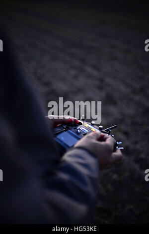 Young man flying a quadcopter DJI phantom drone outdoors Stock Photo