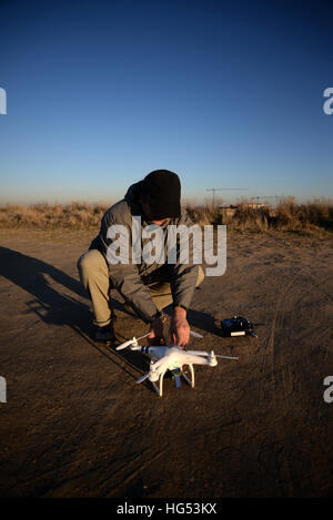 Young man flying a quadcopter DJI phantom drone outdoors Stock Photo