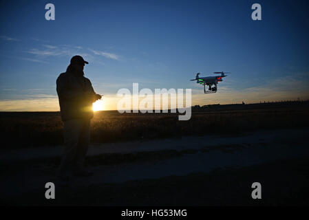 Young man flying Phantom Drone outdoors at sunset Stock Photo