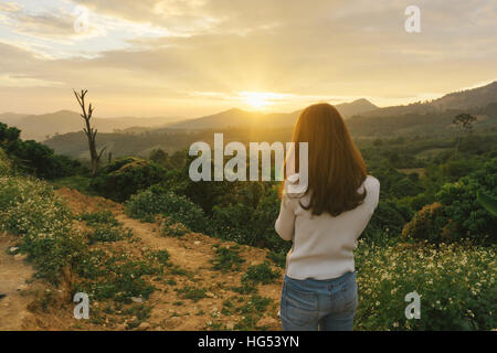 woman hiker taking photo with smart phone at mountain peak cliff. Stock Photo