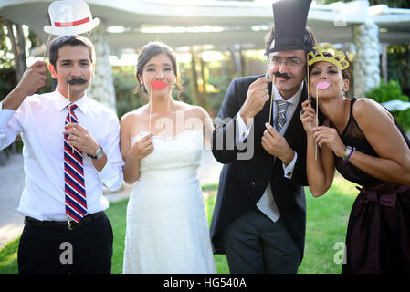 Just married couple playing with costumes and guests in wedding party Stock Photo