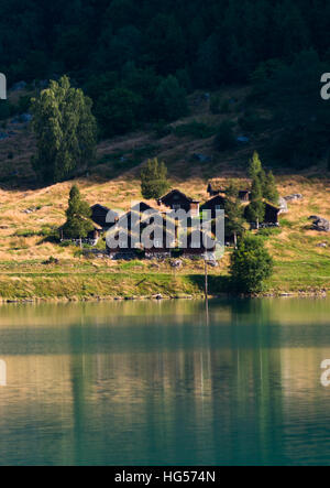 A view across Lovatnet Lake, traditional Norwegian houses topped with sod roof. Stock Photo