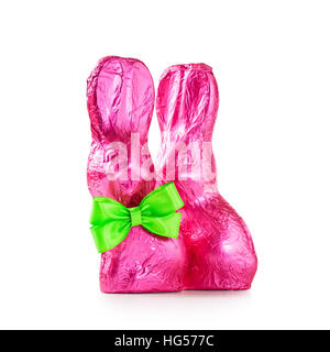 Pair of chocolate easter rabbits, two sweet bunnies with bow wrapped in pink foil isolated on white background clipping path included Stock Photo