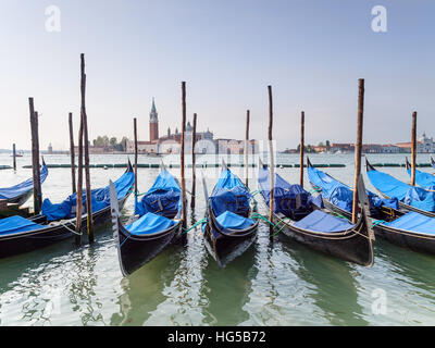 Gondolas moored on the Grand Canal near Piazza San Marco, Venice, Italy, looking towards the Church of San Giorgio Maggiore. Stock Photo