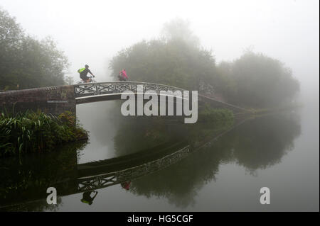 A cyclist on a bridge on Birmingham Canal Navigations (BCN), Birmingham, West Midlands, England, United Kingdom
