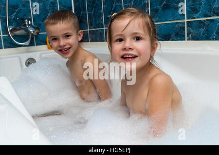 Brother and sister taking a bubble bath. Little boy and girl playing ...