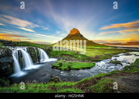 Summer sunset over the famous Kirkjufellsfoss Waterfall with Kirkjufell mountain in the background in Iceland. Stock Photo